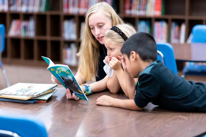 VISTA member reads to two children