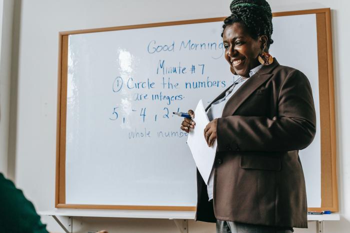 Smiling teacher standing near whiteboard