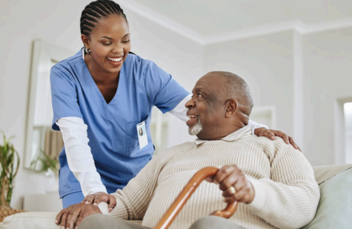 A nurse helps an elderly man.