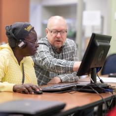 Learner and volunteer work together at computer