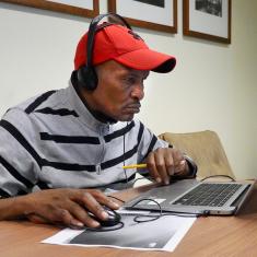 Learner works on laptop from kitchen table