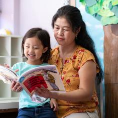 Woman reading book with child