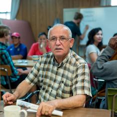 Man with white hair sits in learning environment