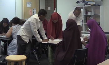 Adult ESL learners talking at a table