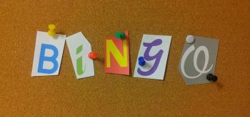 The word bingo spelled out with cut out letters pinned to a cork board