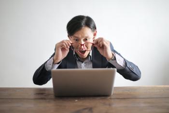 person looking at laptop with delight and amazement