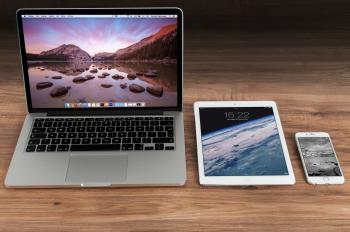 Laptop, tablet, and smartphone lined up on a desk