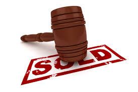 wooden auction gavel and red sold stamp
