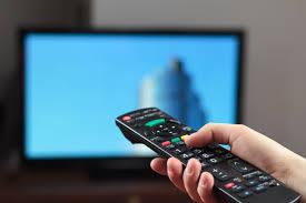 Person aiming remote control at television