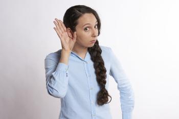 Woman listening with her hand up to her ear