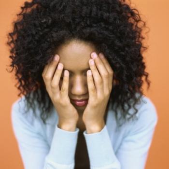 woman covering her face with her hands