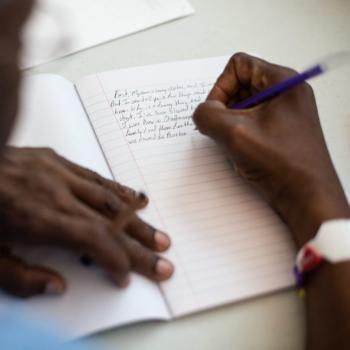 hands writing in a notebook