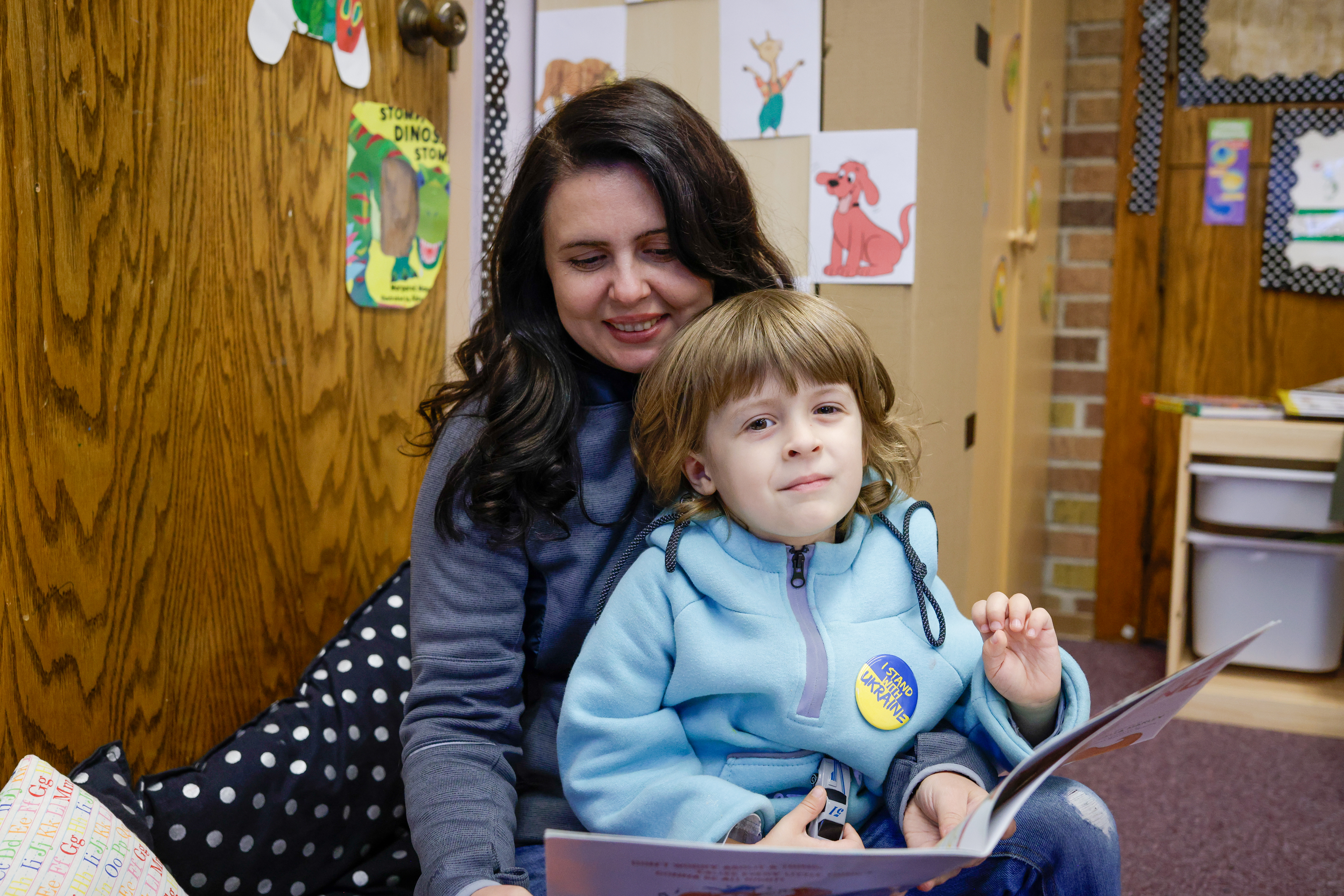 Ivan sits with his mom, Yuliia, as they read a book together.