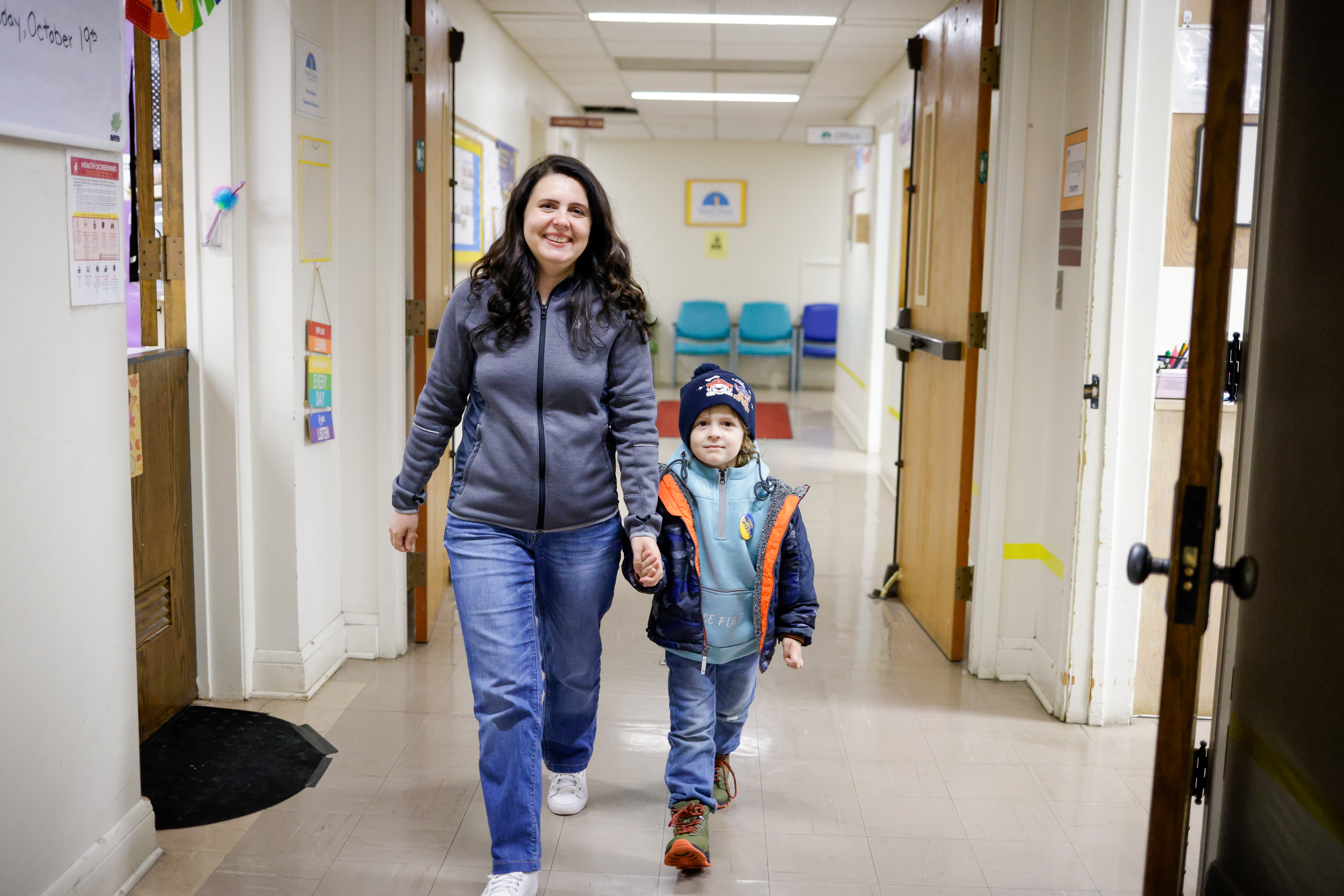 Yuliia and her son Ivan walk down the hallway on their way to their Open Door Learning Center classes
