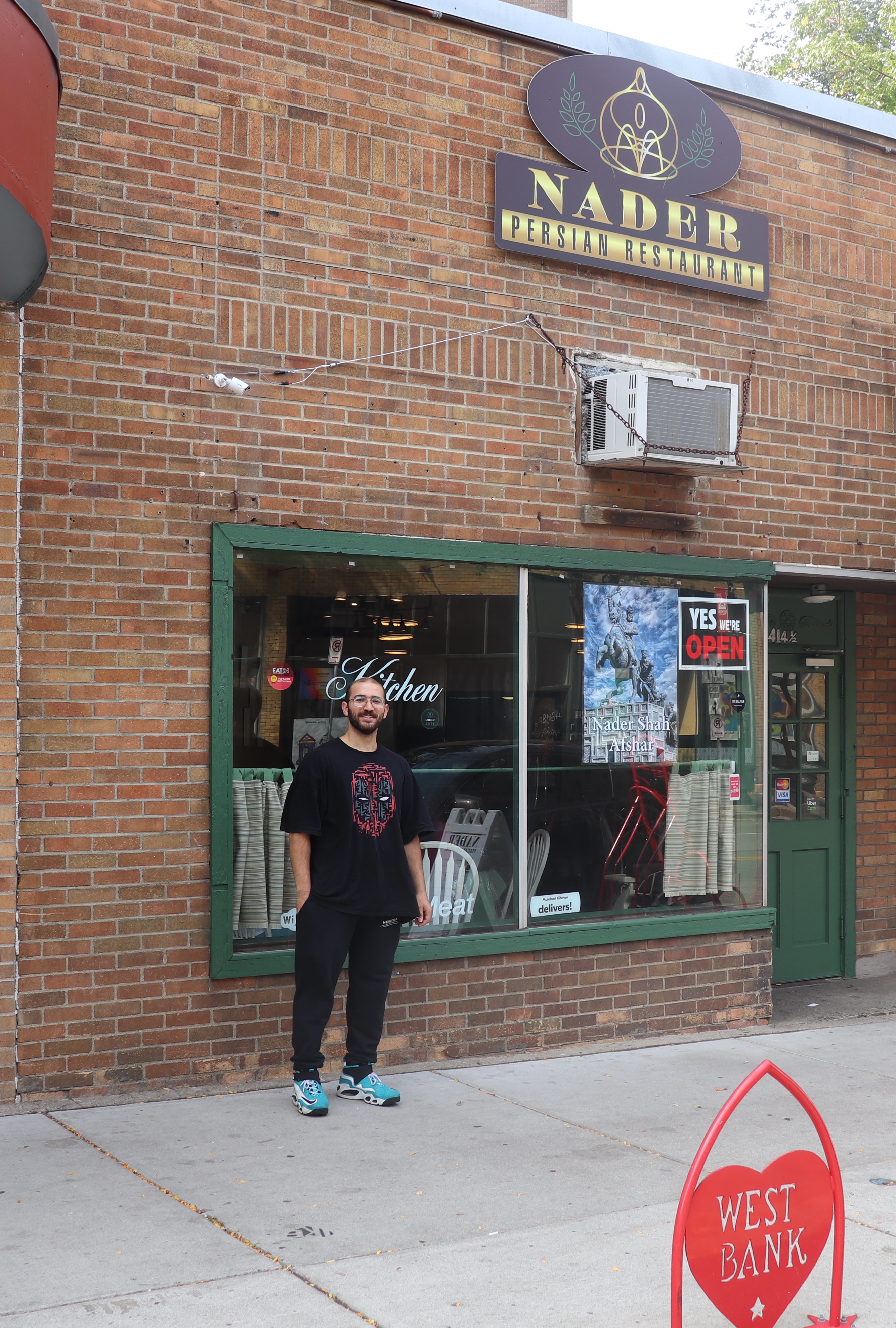 Amir standing on the sidewalk in front of Nader restaurant