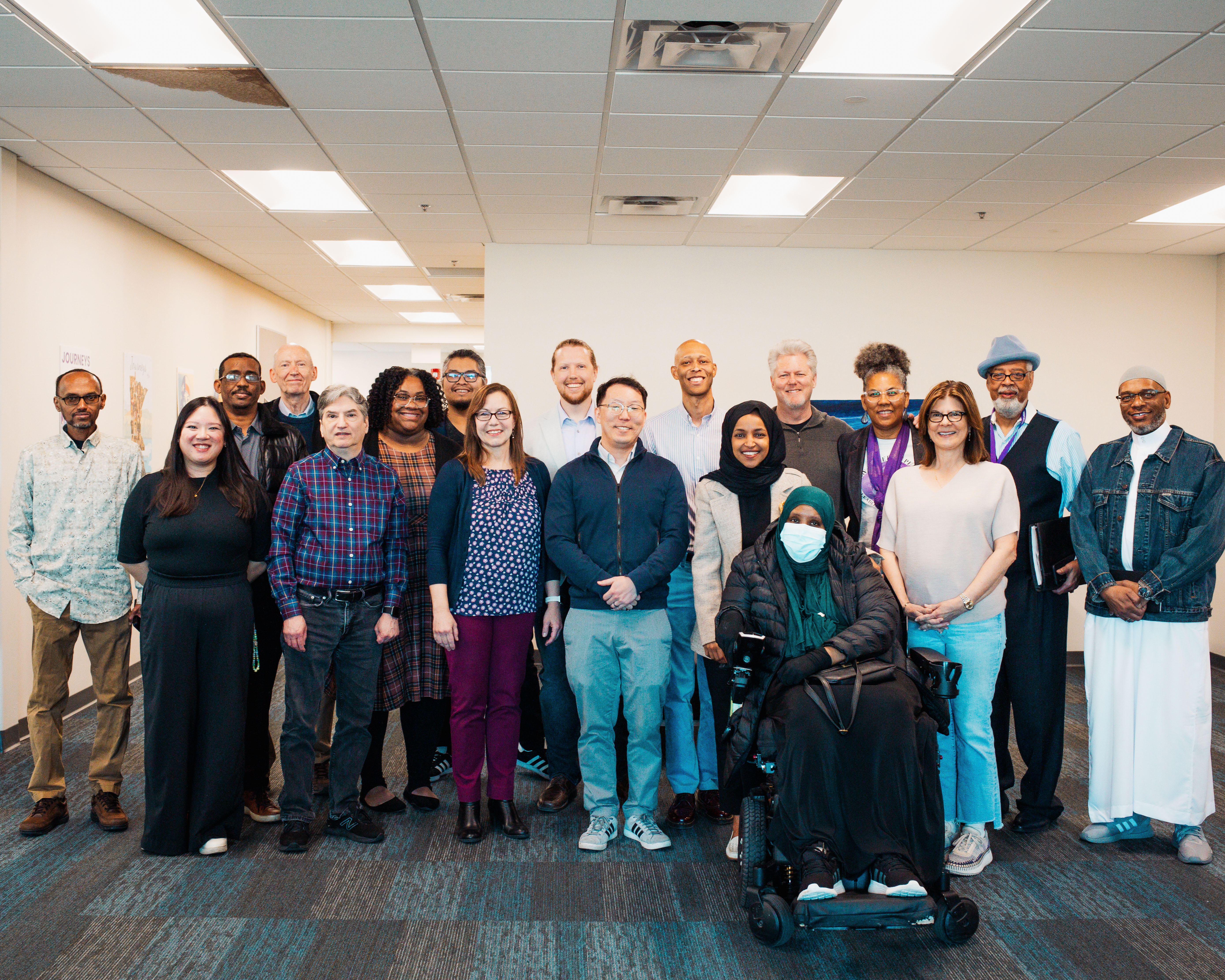 Ilhan Omar poses for a group photo with about 15 Literacy Minnesota community members